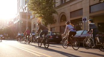 Bike riders travel down the street